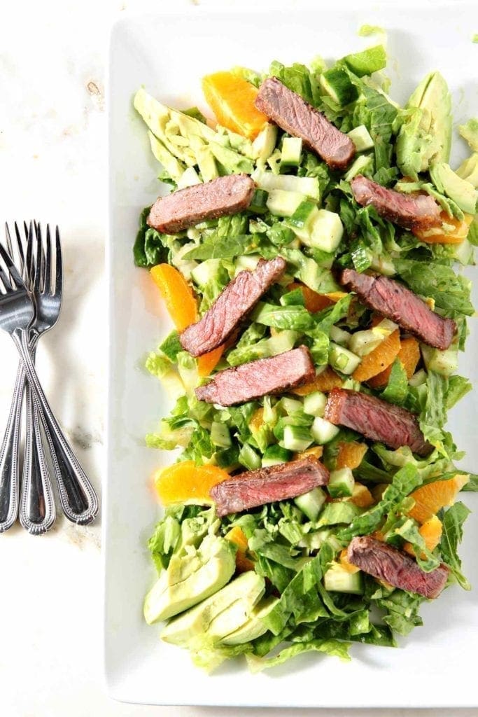 orange steak salad with 3 forks