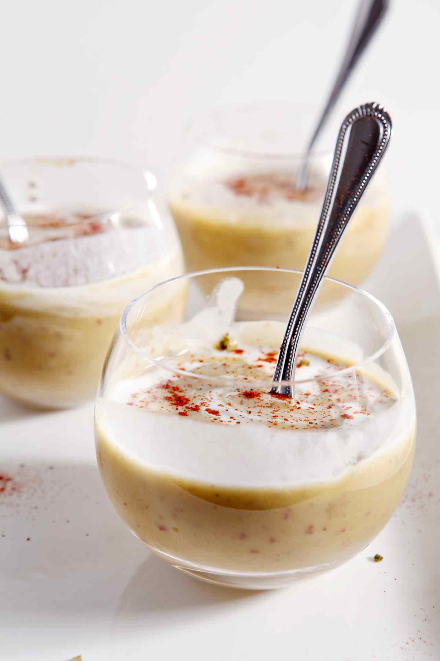 Three bowls of Vegan Potato Leek Soup are served on a white platter