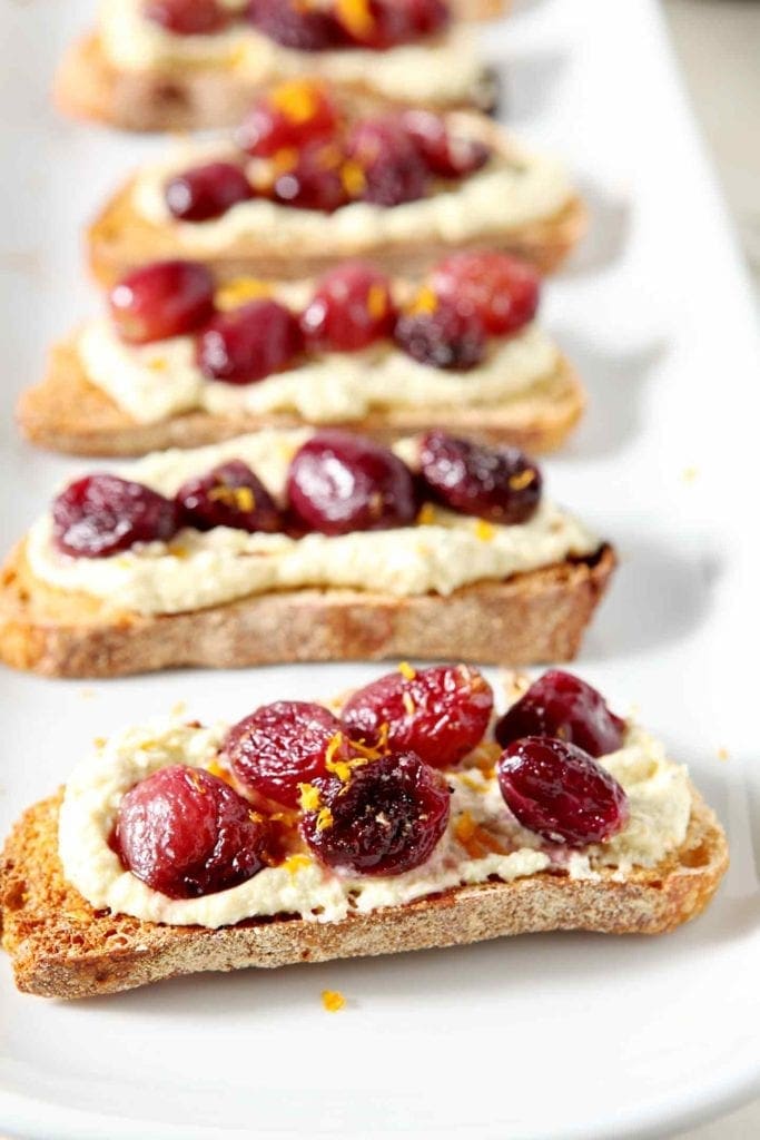 roasted grape bruschetta on a white plate