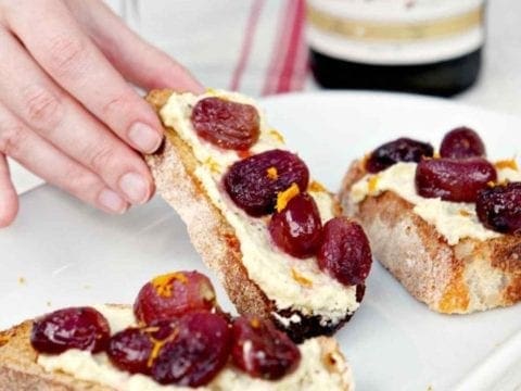hand picking up whipped feta bruschetta