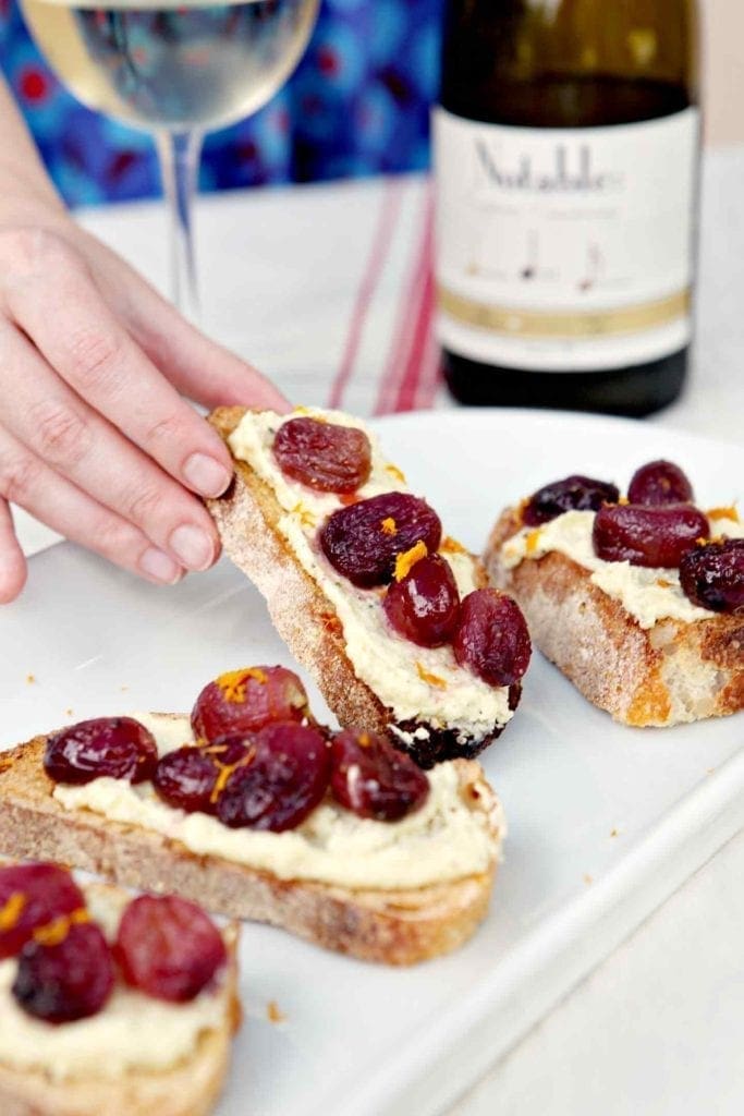 hand picking up whipped feta bruschetta