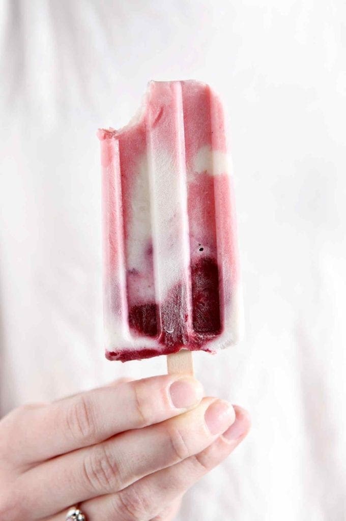 A person holds a bitten-into Patriotic Paleo Popsicle.