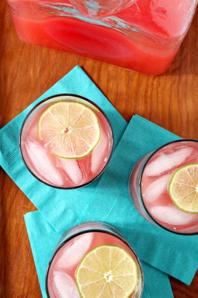 Overhead of three watermelon cocktails garnished with lime rounds