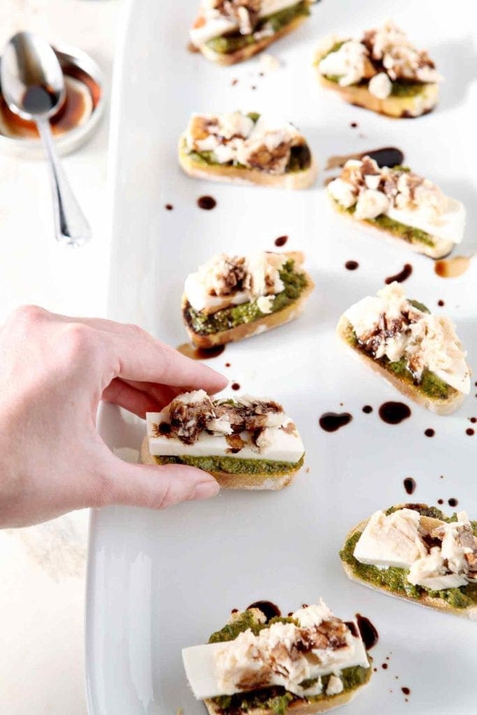 hand grabbing a tuna pesto crostini