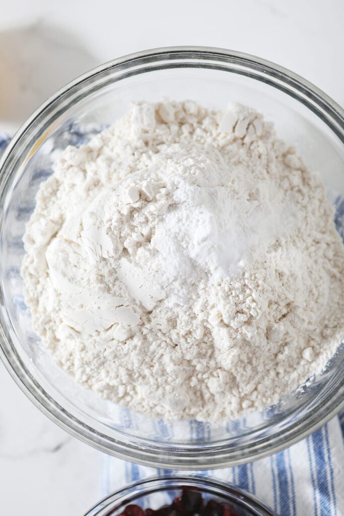 Dry ingredients in a glass bowl on a blue and white striped towel