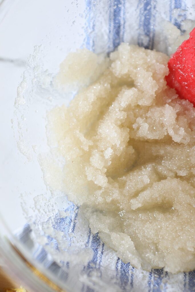 Applesauce, oil and sugar mixed together in a clear glass bowl