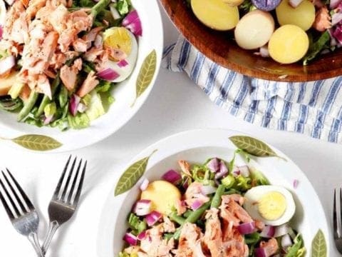 two nicoise salads in white bowls