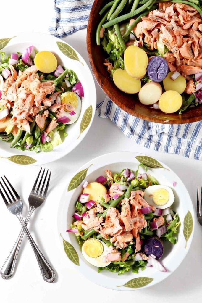 two nicoise salads in white bowls