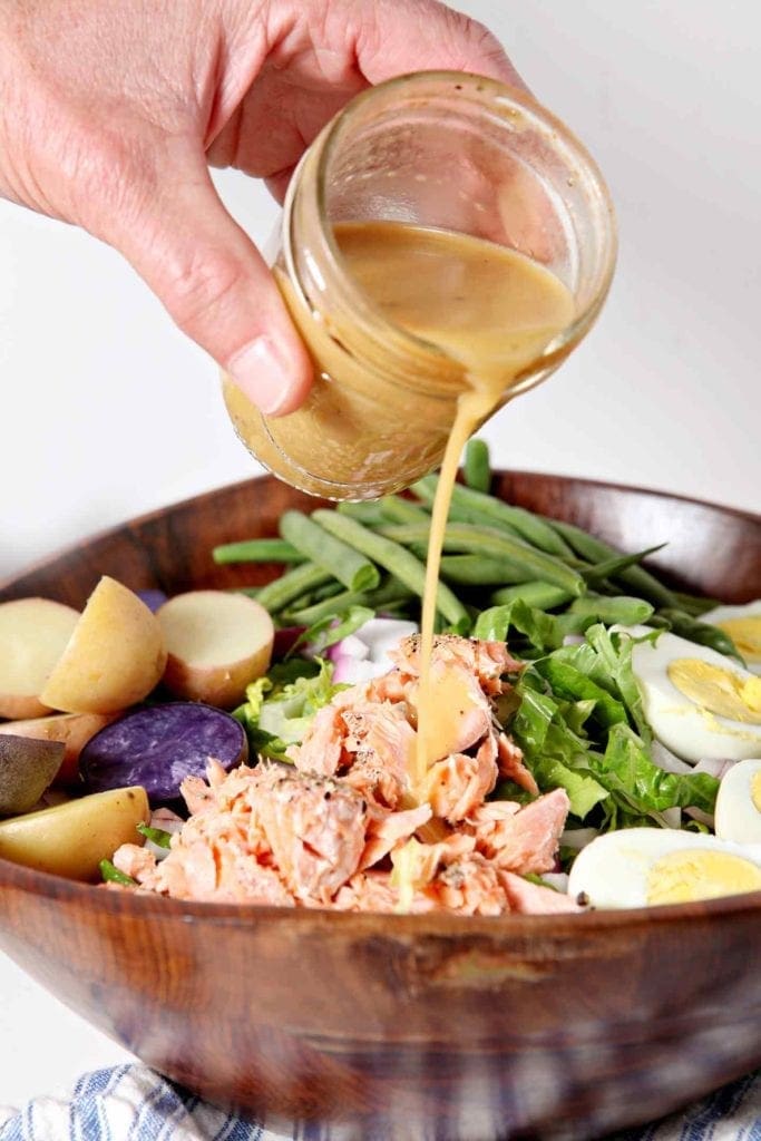 pouring dressing on a salad