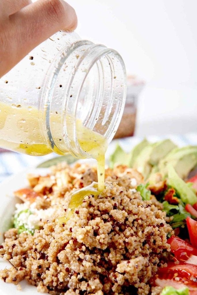 pouring dressing on quinoa