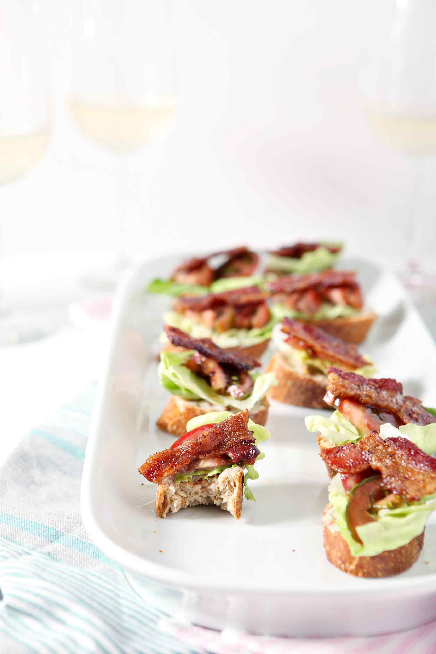 A platter of several BLT Bruschetta, laid out before a baby shower on a light pink towel