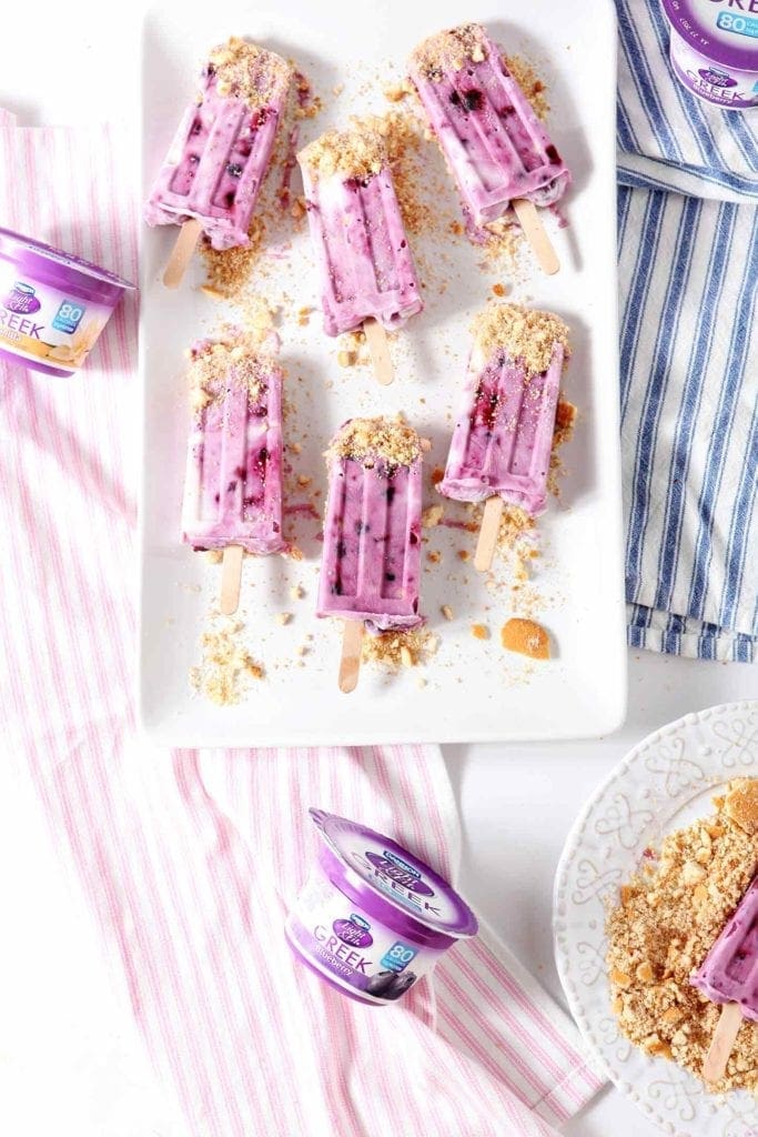 blueberry cheesecake popsicles on a white plate