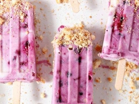 blueberry cheesecake popsicles on a white surface