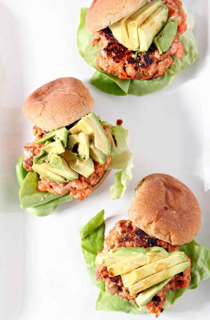 three salmon burgers on a white plate