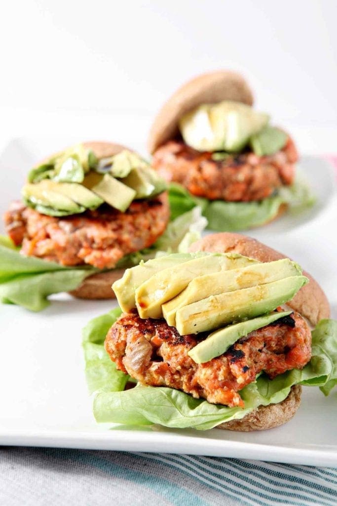 salmon burgers topped with avocado