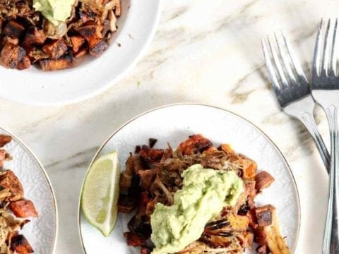 slow cooker pork carnitas on white plates with silver forks