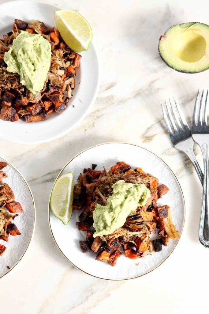 Three Whole30 Slow Cooker Pork Carnitas Plates sit on a marble background, layered and ready for eating