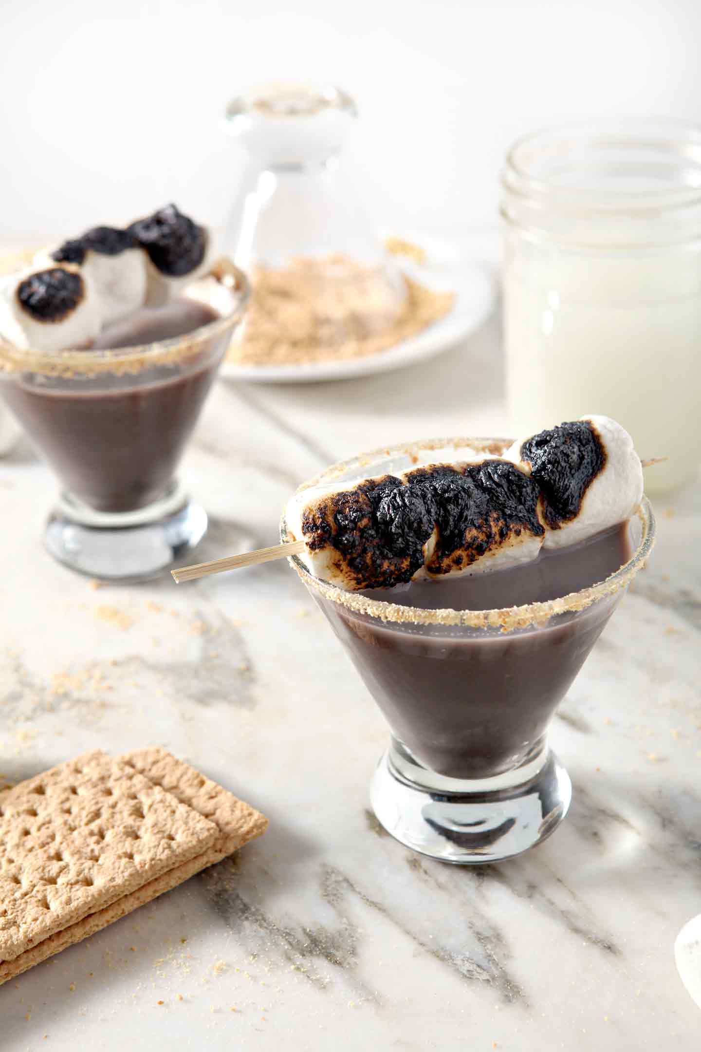 smores martinis in glasses topped with marshmallows