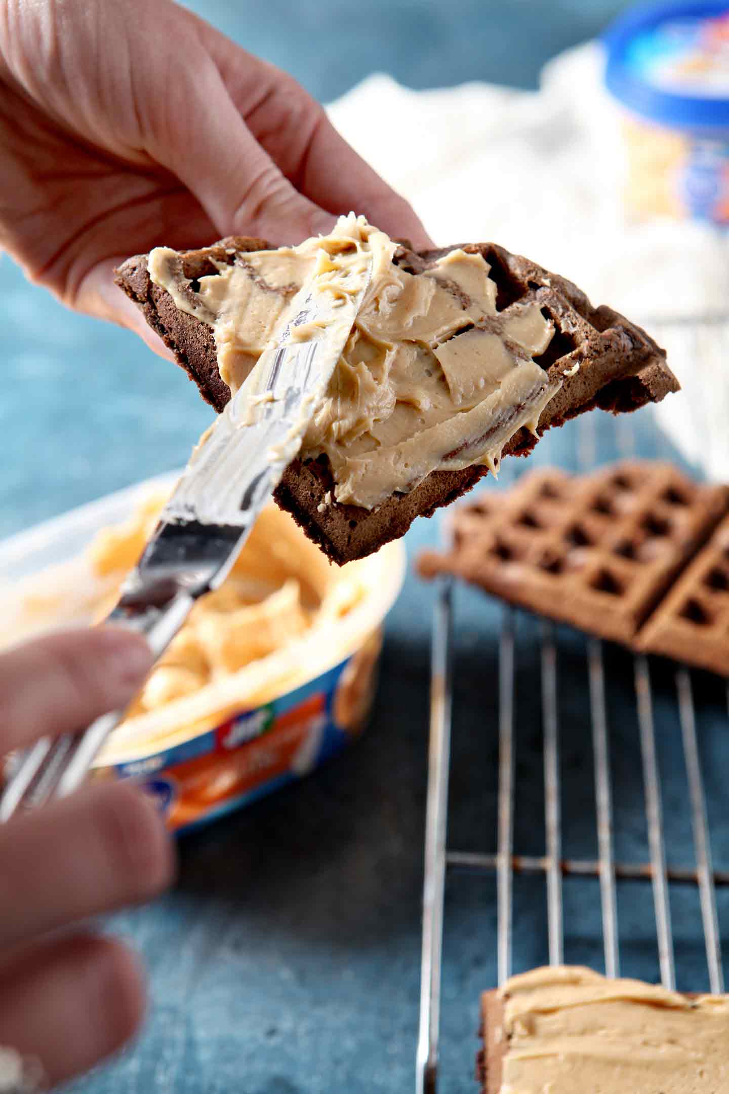 spreading peanut butter on a waffle