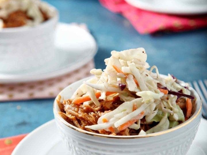 Two Pumpkin Pulled Pork Bowls sit on a blue background with colorful pink and orange napkins