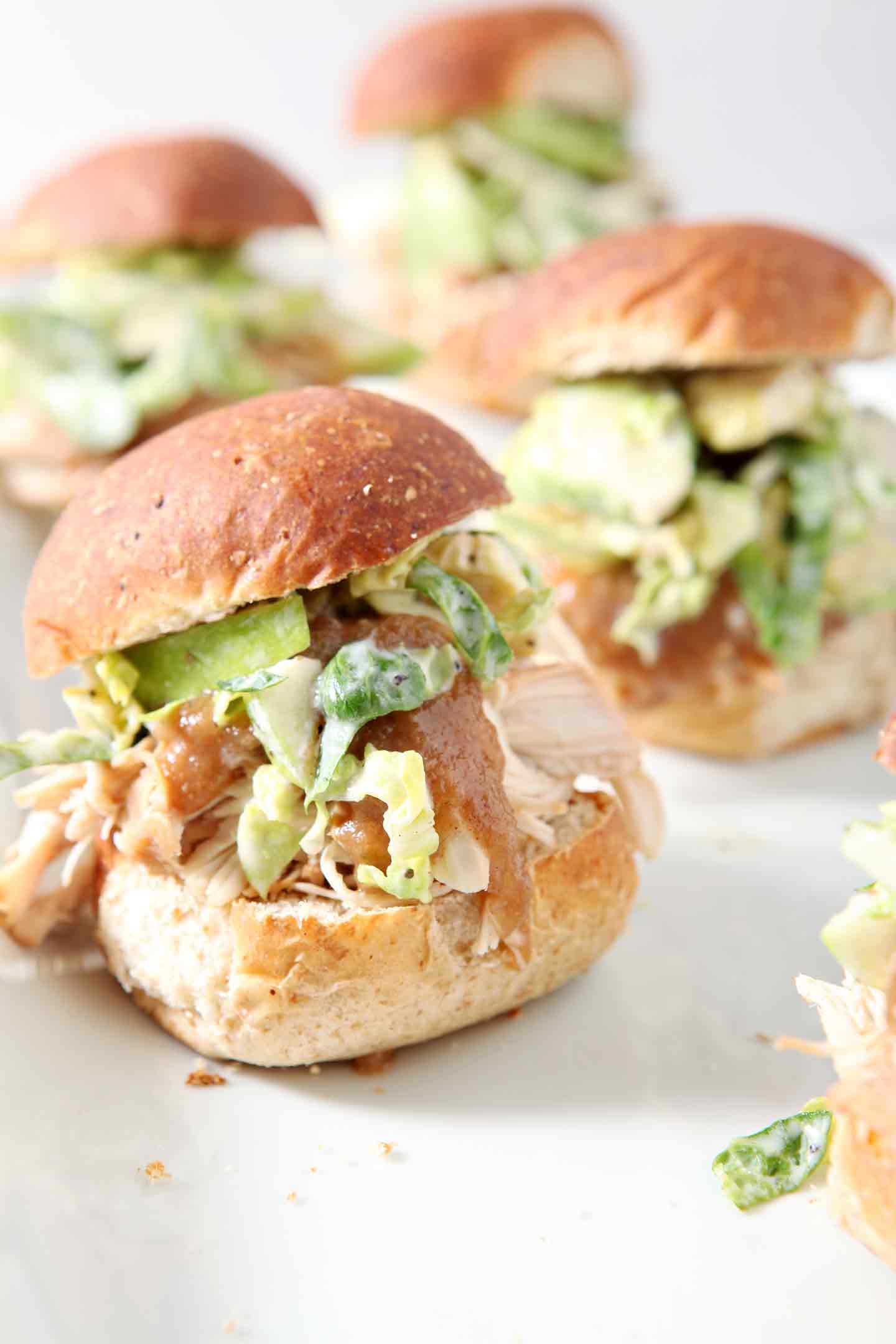 A platter of Shredded Applesauce Chicken Sliders with Brussels Sprouts Apple Slaw for serving