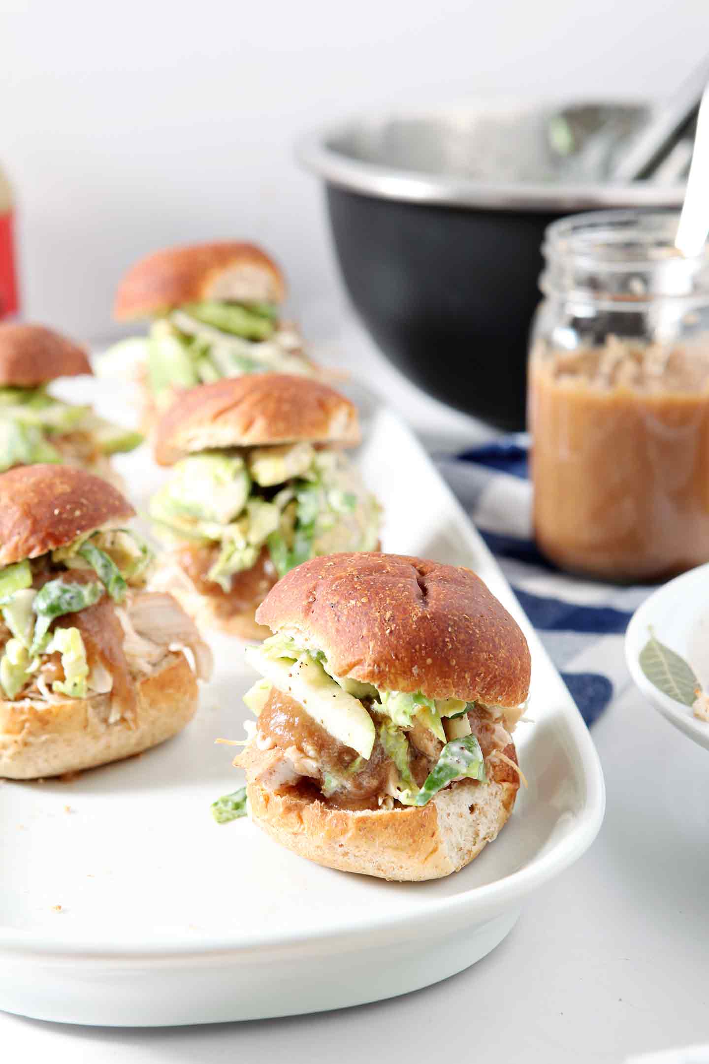 chicken sliders on a white tray with applesauce in the background