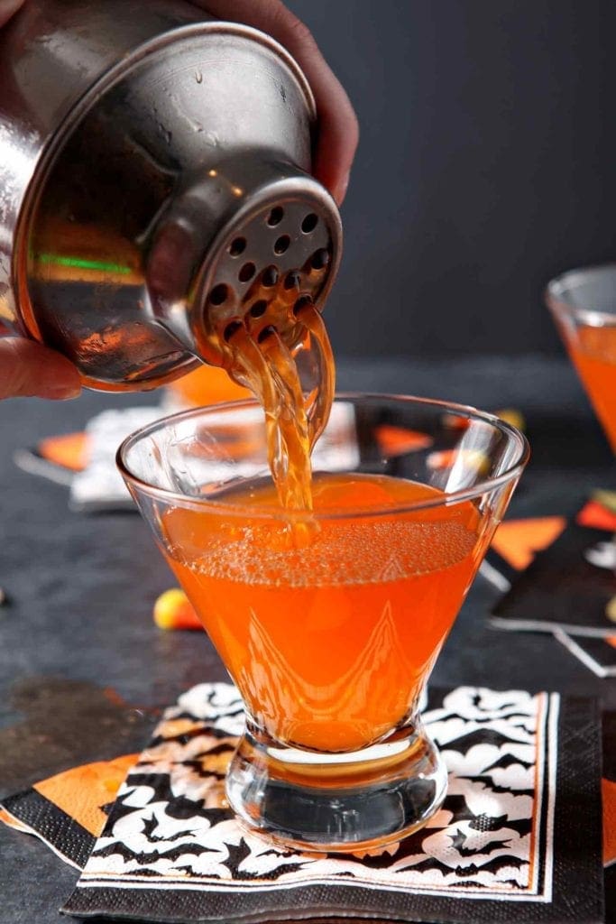 Candy corn vodka is poured into a martini glass