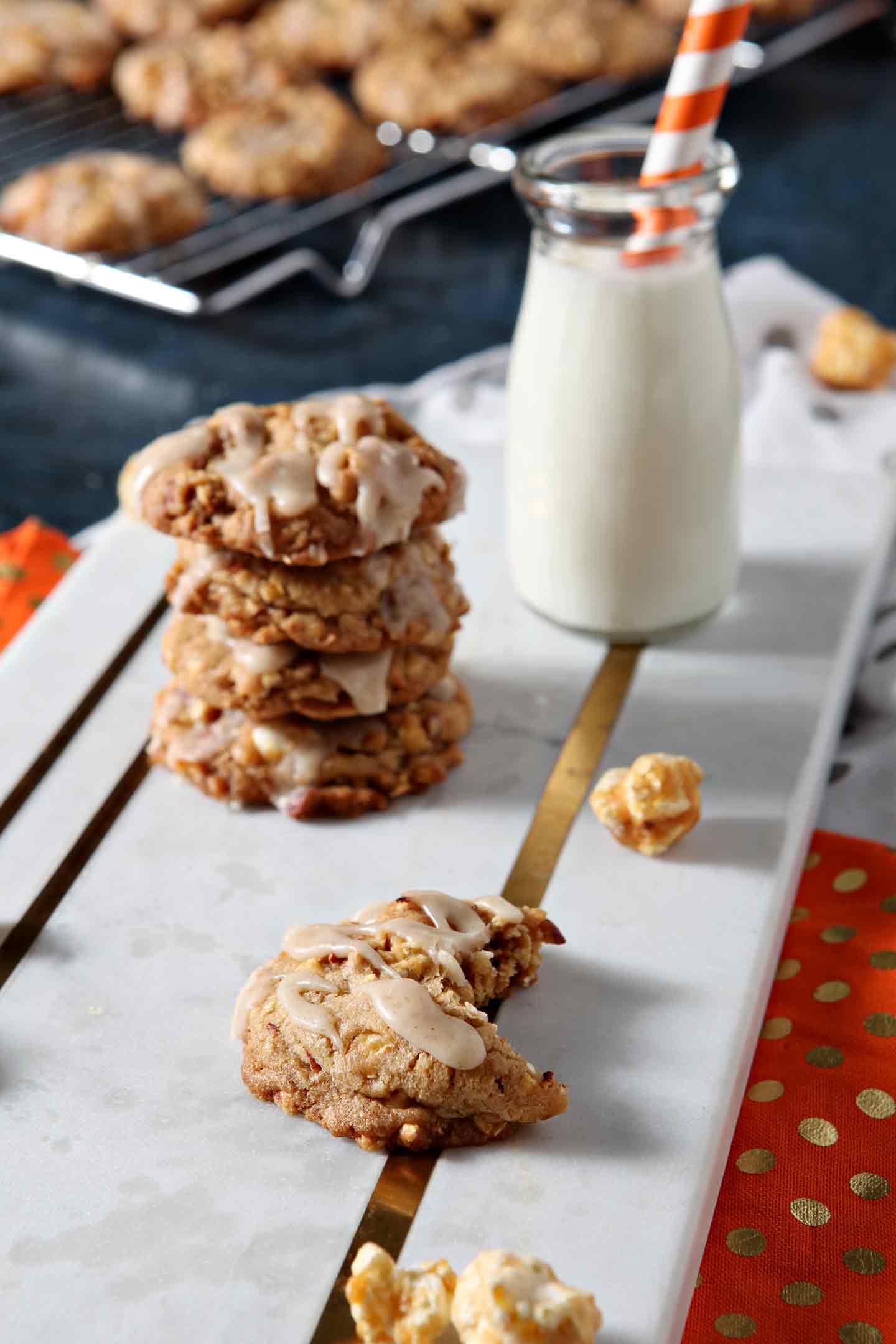 caramel corn cookies stacked on a white tray with milk