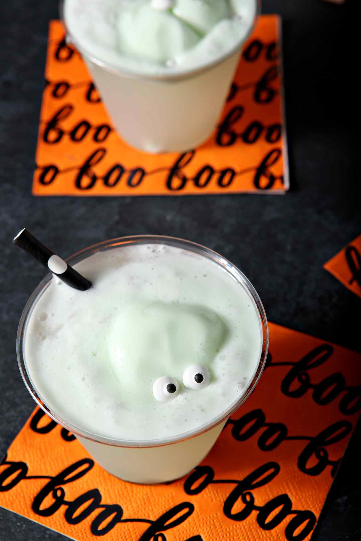 Two glasses of a Halloween drink for kids display the candy eyeballs