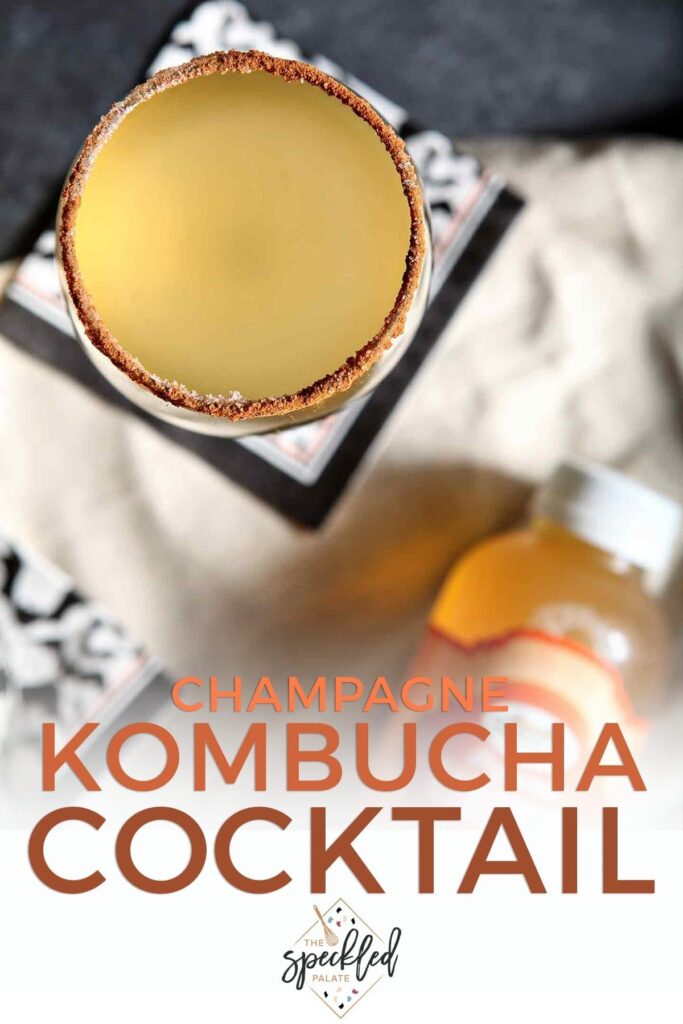 Overhead of a glass of golden liquid rimmed with and the text 'champagne kombucha cocktail'