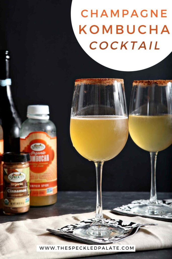 Two glasses holding pumpkin spice cocktails and the ingredients behind them on a black surface with the text 'champagne kombucha cocktail'