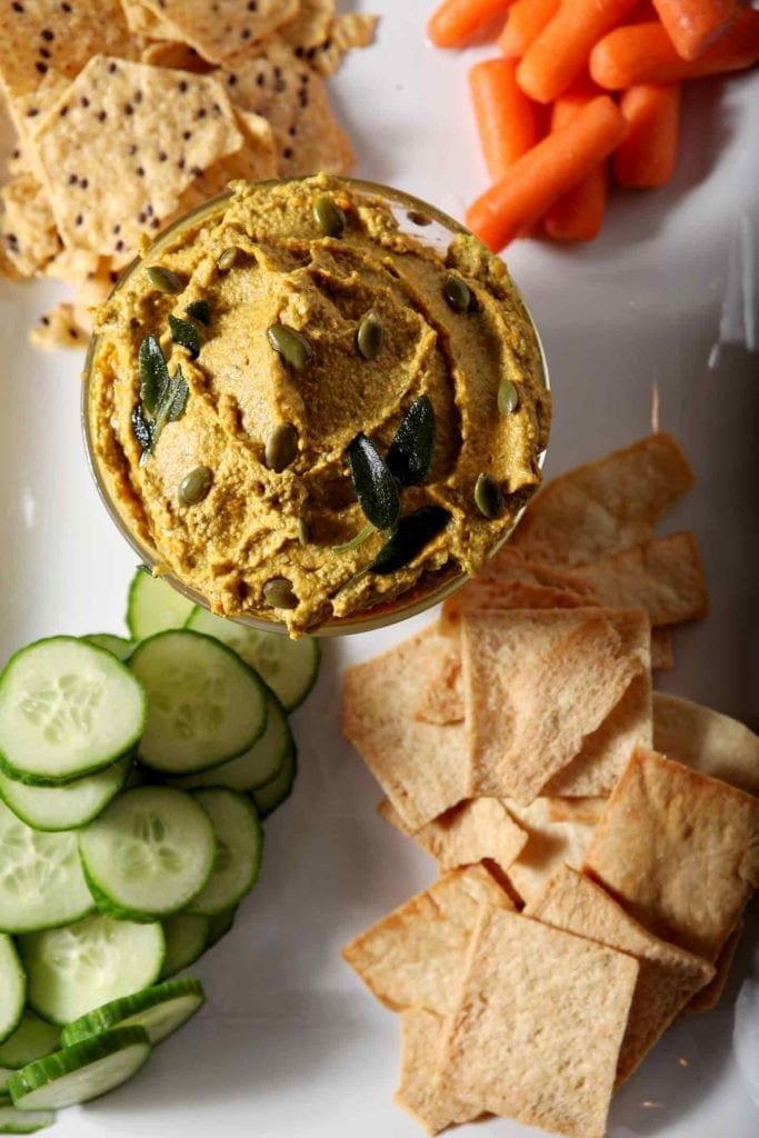 Overhead of the savory pumpkin dip, with cucumbers, carrots and chips