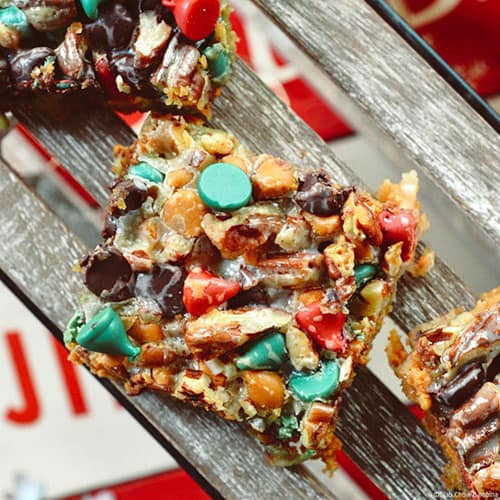 A close up on a Holiday Hello Dolly Cookie Bar on a wooden countertop