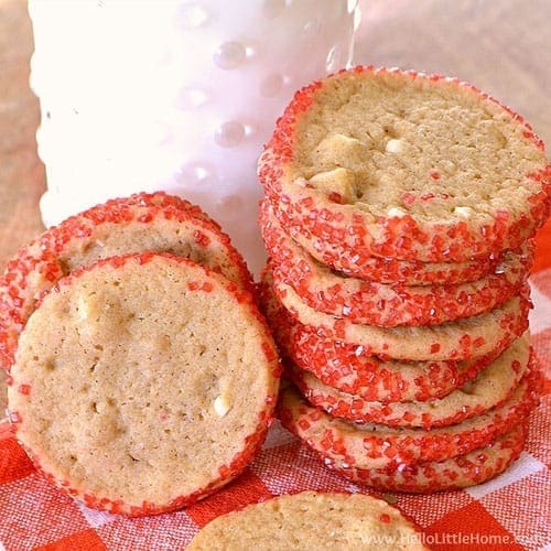 A stack of homemade honey cookies with red sprinkles rolled on the edges.