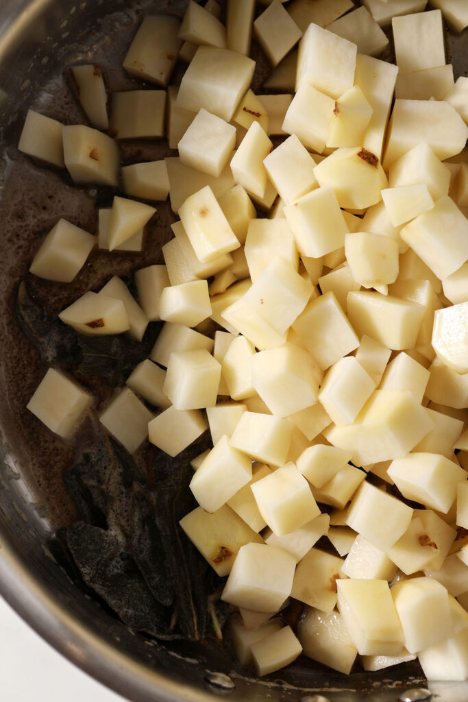 Diced potatoes on top of brown butter in a skillet