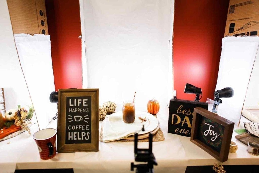 A photo station at the Sprouts Blogger Retreat with lights, fall decor and signs