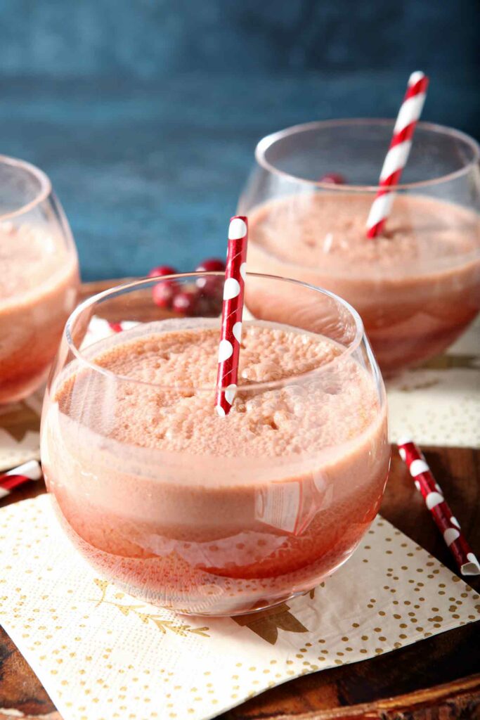 Close up of two clear glasses holding Cranberry Pumpkin Cold Brew Coffee Drinks with red polka dot straws in them