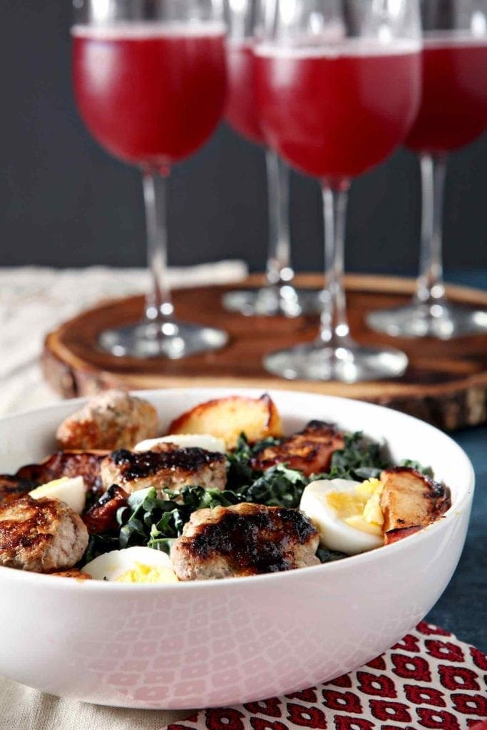 A bowl of Thanksgiving brunch salad on a table with other brunch items