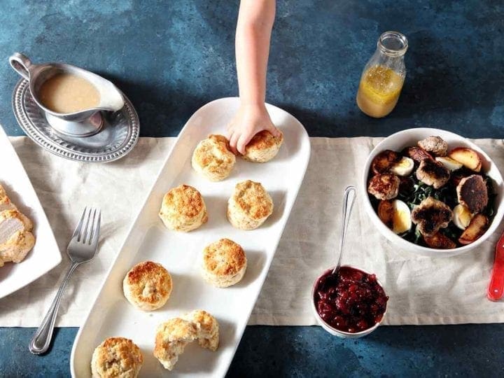 hand grabbing a turkey biscuit from a white plate