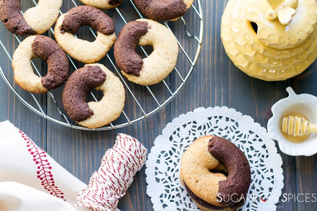An abbracci italian cookie on a plate and six on a drying rack in the background.