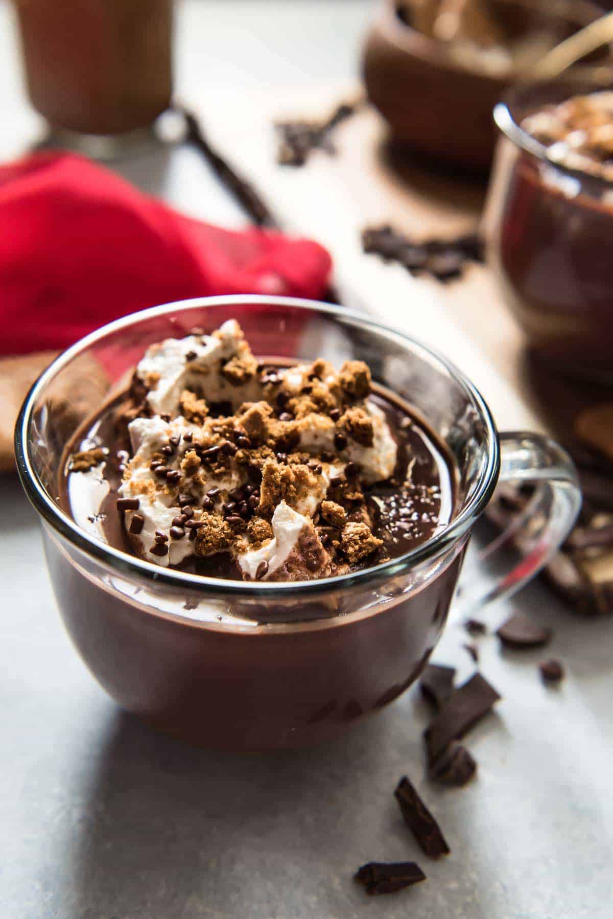 A close up of a glass mug of cookie butter hot chocolate with cookie butter topping.