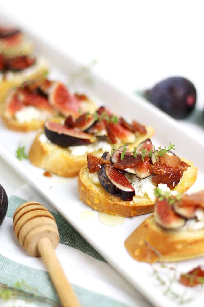 fig and goat cheese crostini on a white plate