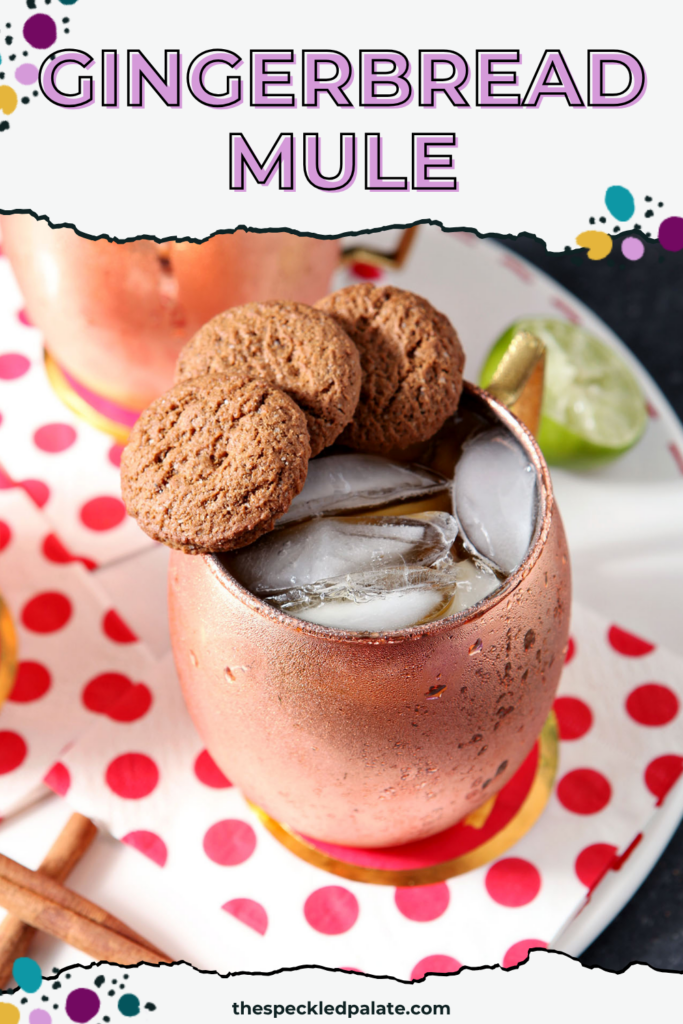 Two copper mugs of drinks, garnished with three gingersnaps on the rim, sit on a white tray with decorative red and white napkins with the text gingerbread mule