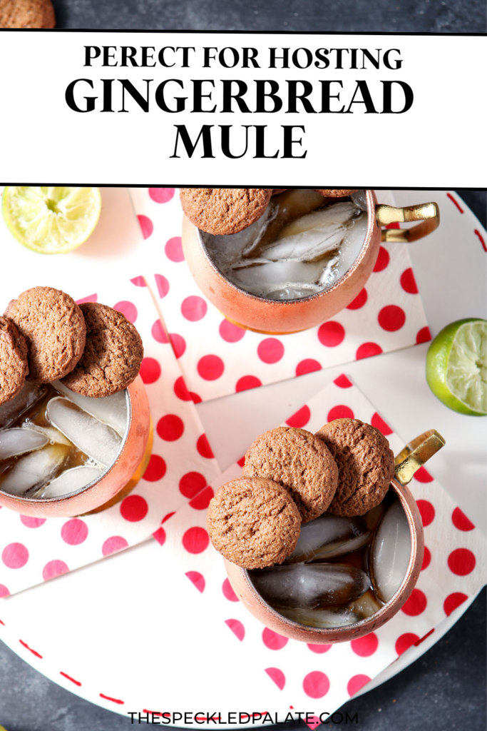 Three copper mugs holding Gingerbread Mules, garnished with ginger snaps, sit on a white platter with decorative dotted red napkins on a dark surface with the text perfect for hosting gingerbread mule