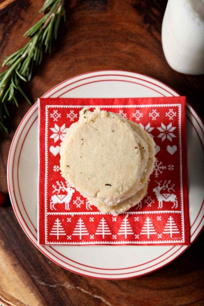 a stack of ginger rosemary shortbread cookies on a plate with a red napkin