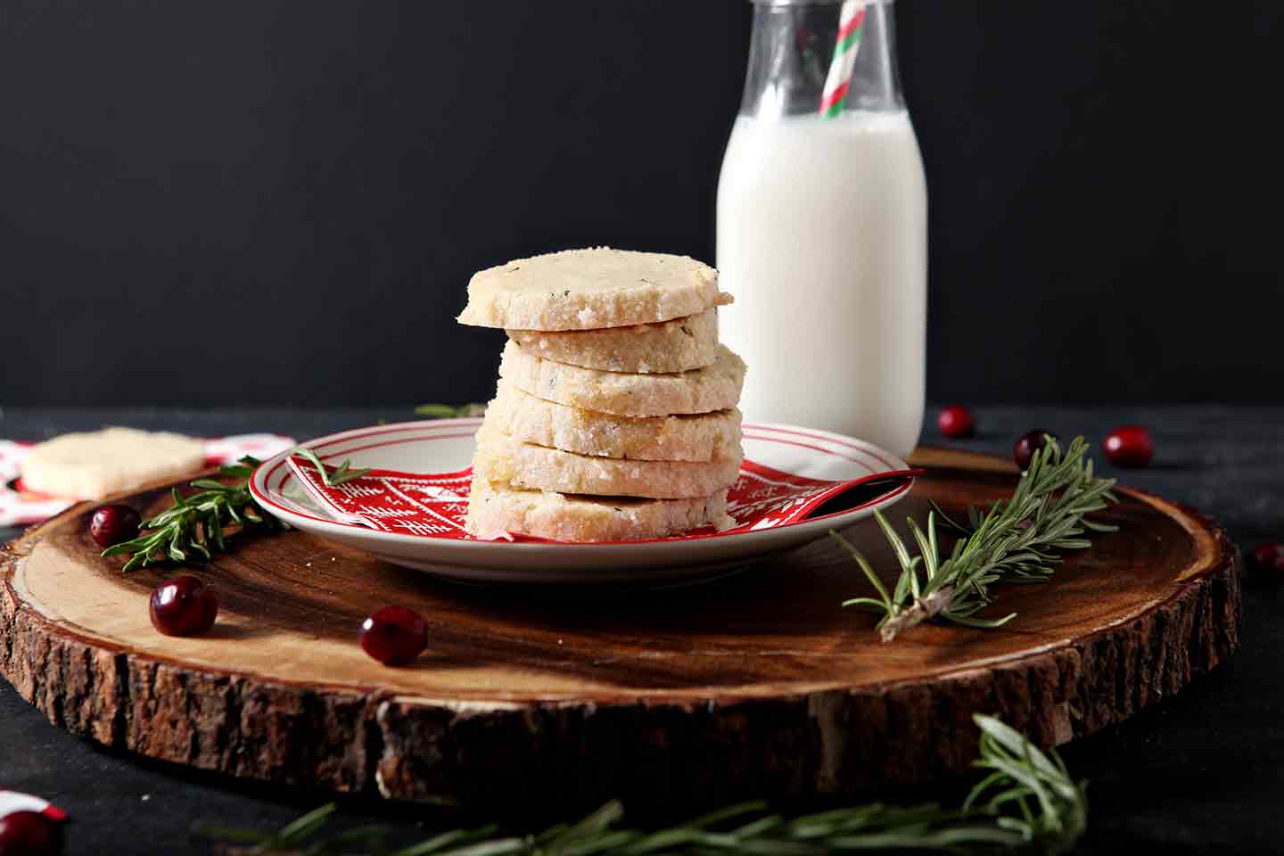 a stack of ginger rosemary shortbread cookies on a plate with milk