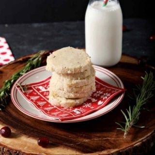 a stack of ginger rosemary shortbread cookies on a plate with milk