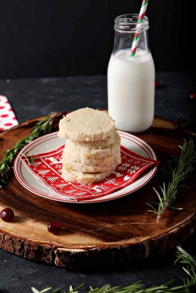 a stack of ginger rosemary shortbread cookies on a plate with milk