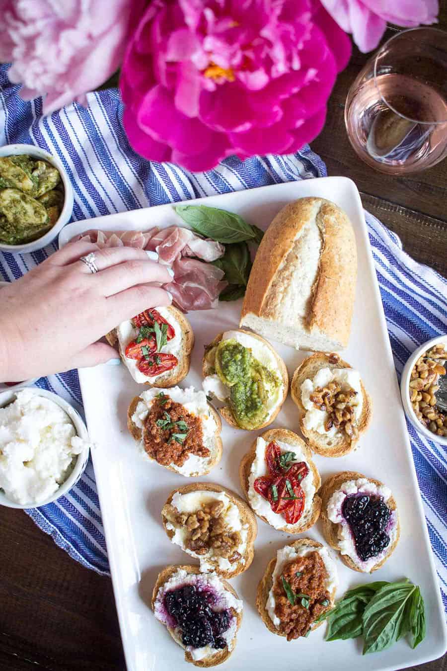 A tray of hand picking up a piece of ricotta toast 