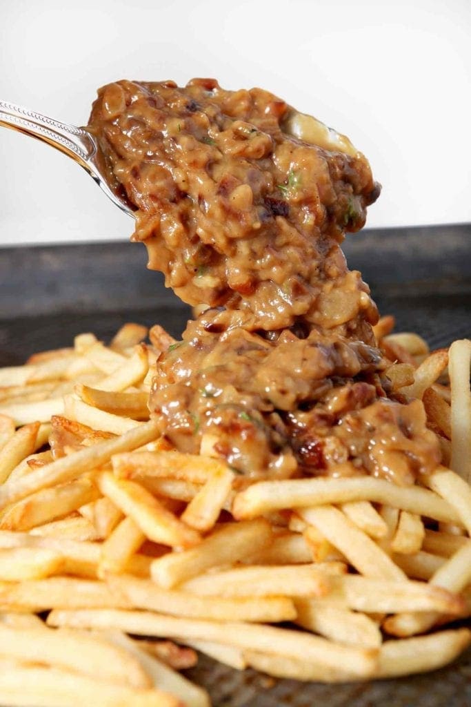 spooning gravy onto french fries